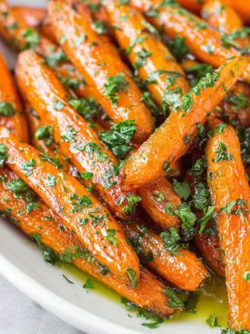 A plate of homemade honey butter glazed carrots on a white kitchen counter