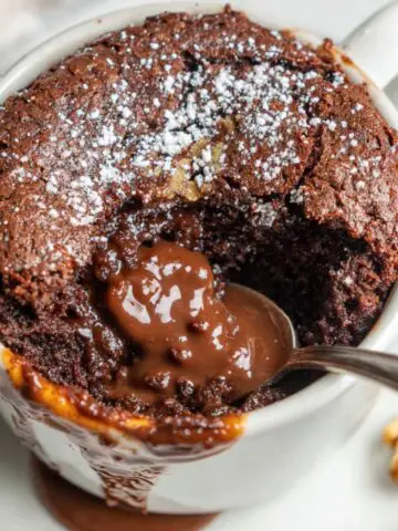 Top view of a homemade Nutella mug cake on a white kitchen counter with natural light.